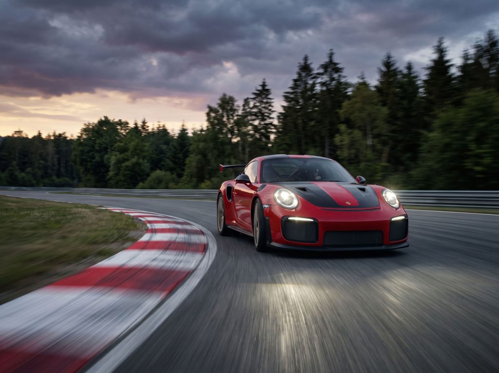 Image d'une Porsche au coucher du soleil prise à pleine vitesse sur un circuit.